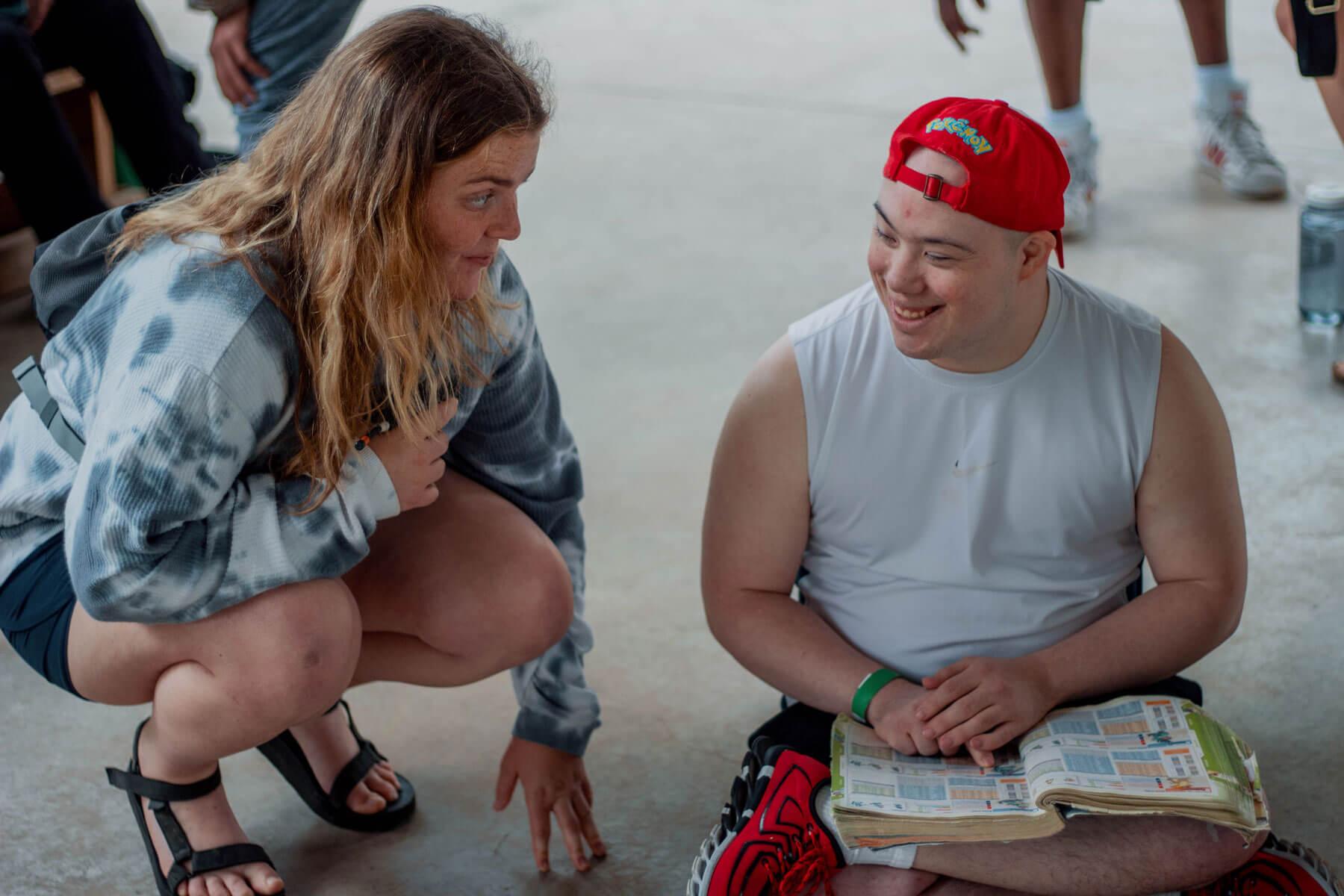Camp counselor talking to a camper reading the bible