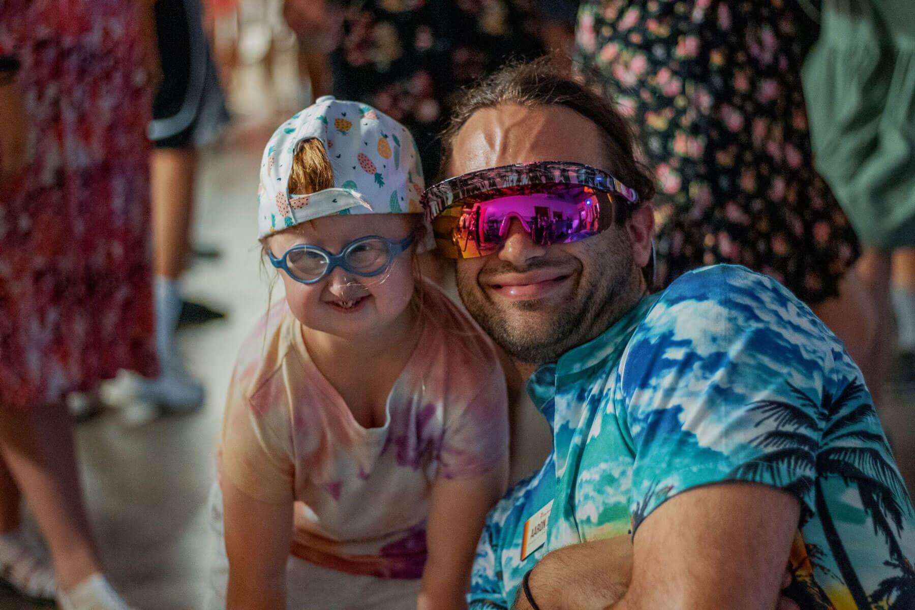 Camp counselor next to a young summer camper smiling