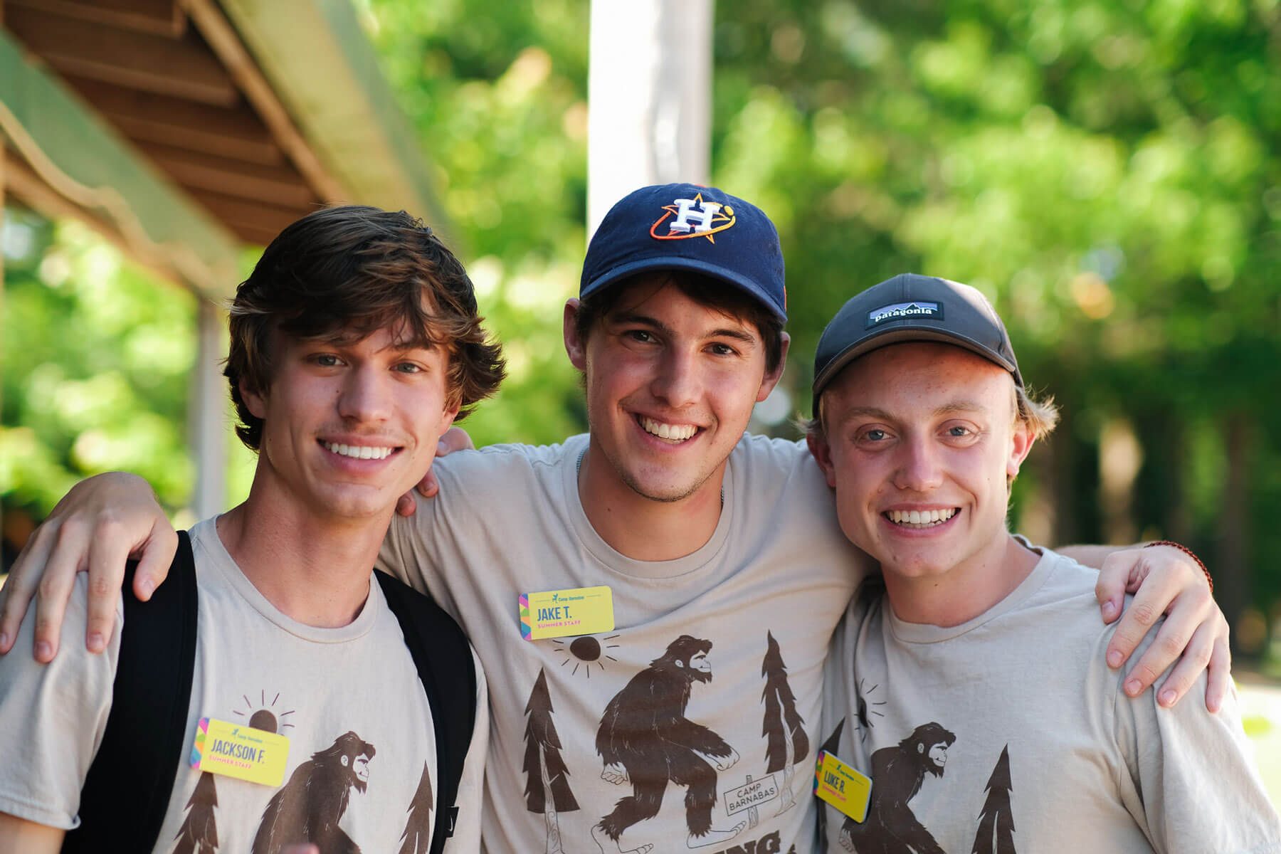 Camp counselors smiling, wearing hats