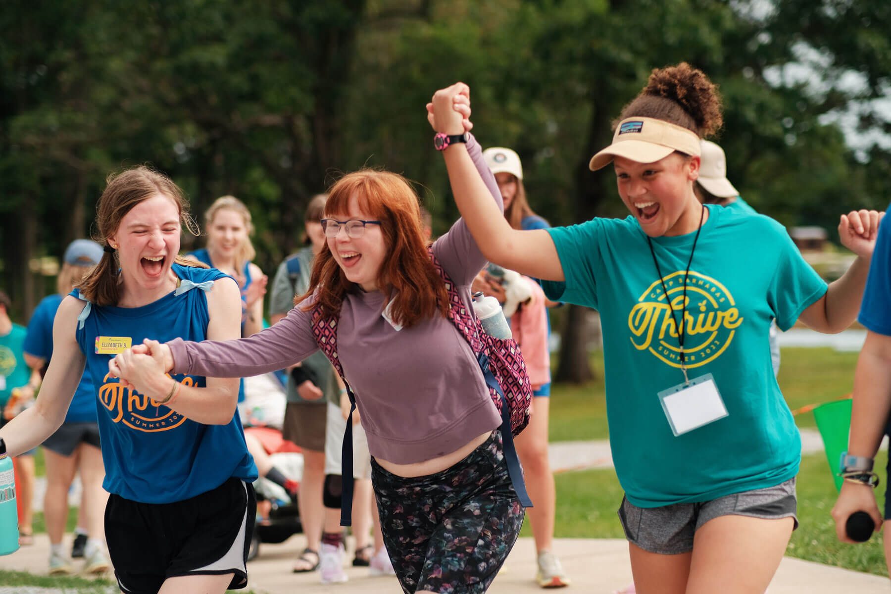 Camp counselors walking hand in hand smiling and laughing
