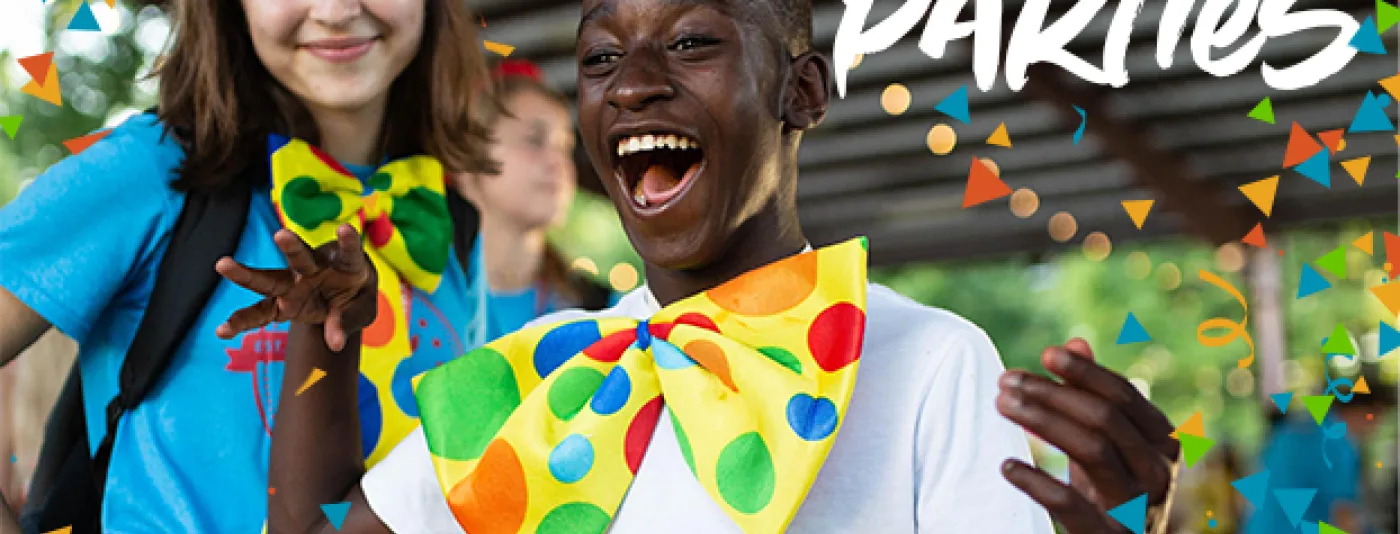Camper smiling with camp counselor wearing large, funny neckties