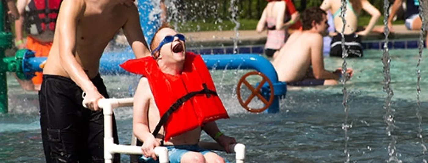 Counselor and camper at a water park splashing around