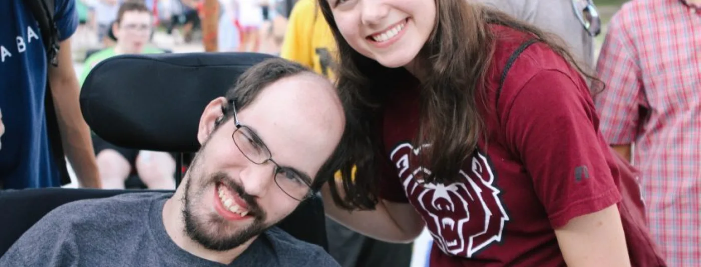 Camp counselor next to a camper smiling