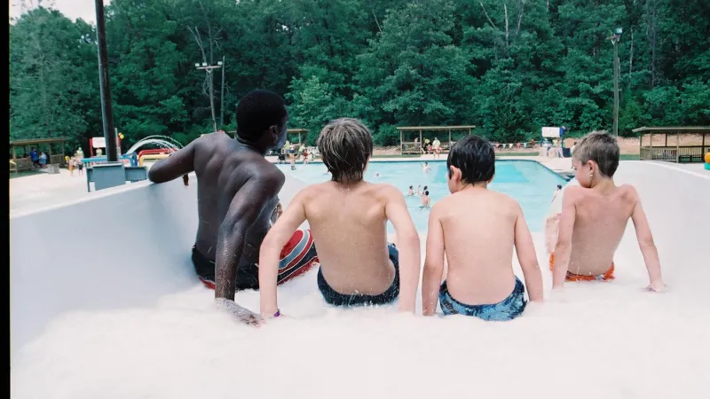 Kids swimming at a summer camp pool