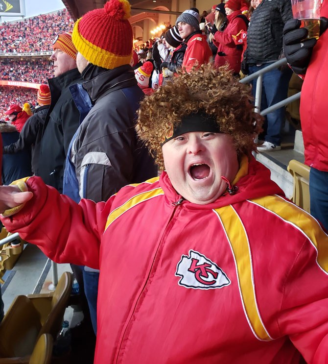 Young boy wearing a Kansas City Chiefs jacket at a game